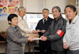 17日、仙台の現地対策本部で募金を手渡す笹山、渡辺両県議。